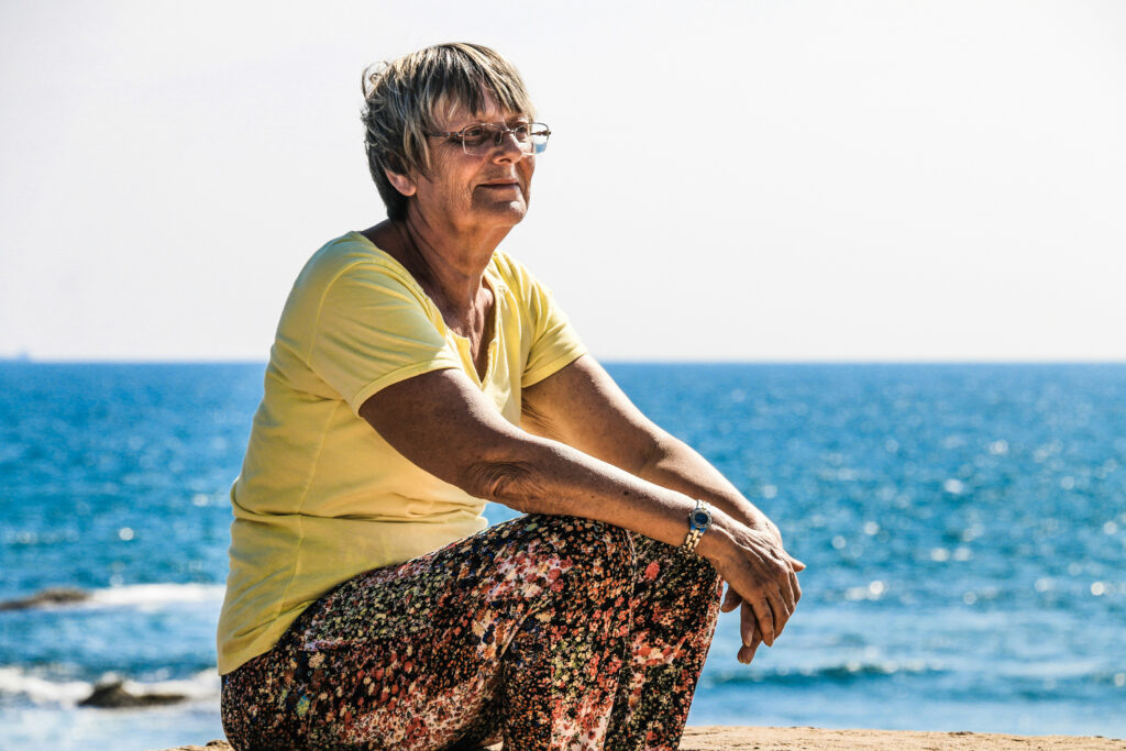 older lady sitting by beach