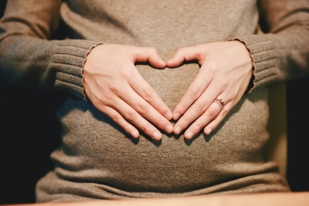 pregnant woman with heart hands